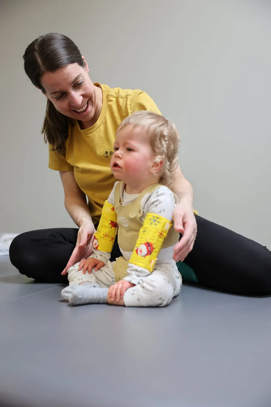 Pediatric therapist Rebecca Allen smiling and working with a young child during a play-based therapy session
